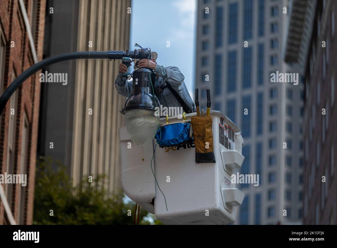 Operaio che ripara una lampada da strada nel centro di Atlanta Foto Stock