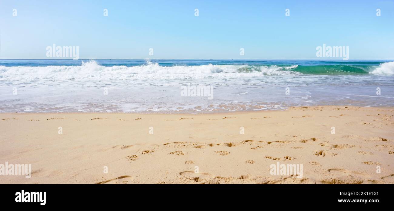 Una scena panoramica sunswept con onde da surf dall'Oceano Pacifico che si schiantano su una spiaggia sabbiosa sulla Sunshine Coast, Australia. Una posizione idilliaca per Foto Stock