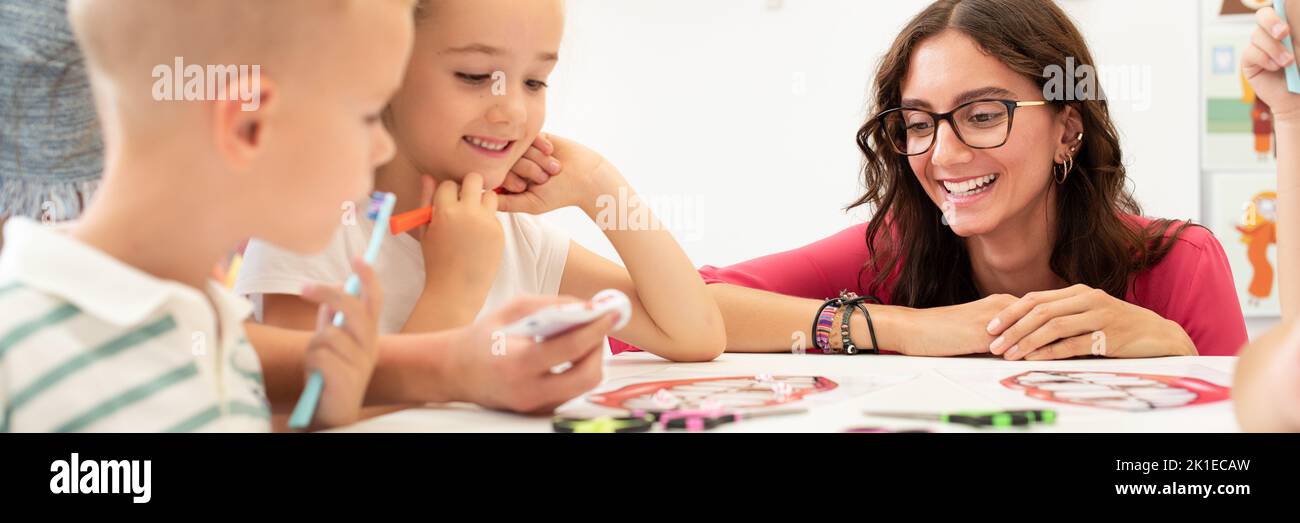 Sessione di terapia occupazionale per bambini. Gruppo di bambini che fanno esercizi giocosi con il loro terapeuta. Studenti in classe. Foto Stock