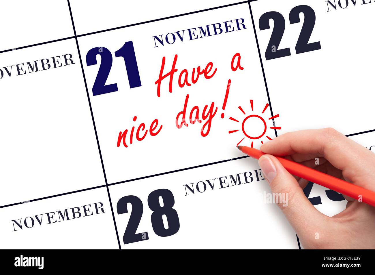 21st° giorno di novembre. La mano che scrive il testo hanno un bel giorno e disegnare il sole sulla data del calendario 21 novembre. Salvare la data. Mese autunnale, giorno Foto Stock