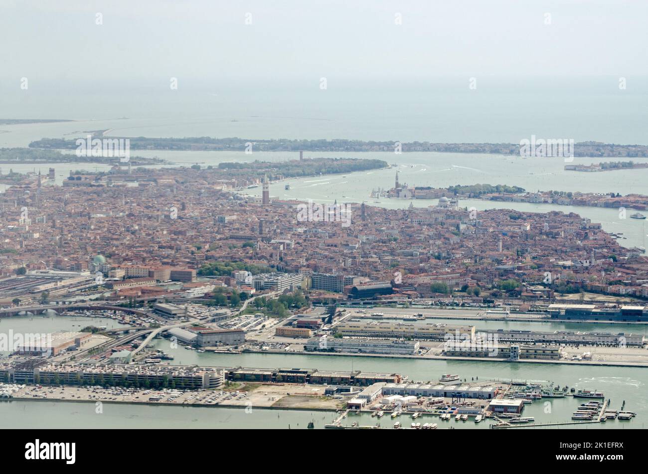 Vista da un aereo che si avvicina all'aeroporto Marco Polo guardando attraverso il centro storico di Venezia con il terminal delle navi da crociera e le strutture di trasporto Tronchetto Foto Stock