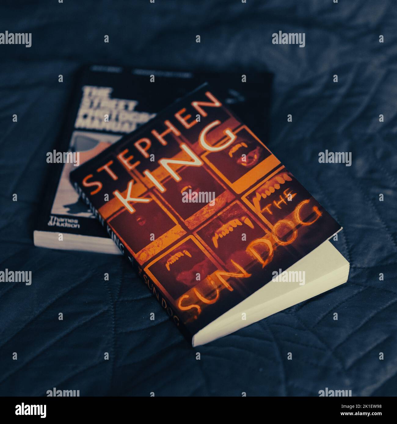 Il romanzo di Stephen King The Sun Dog che si posa su un letto blu Foto Stock