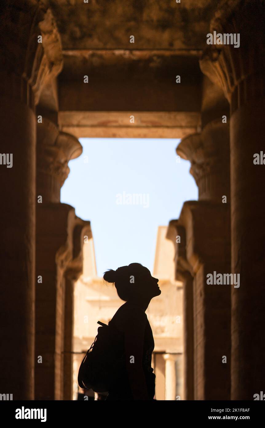 Silhouette di una donna che guarda un tempio egiziano Foto Stock