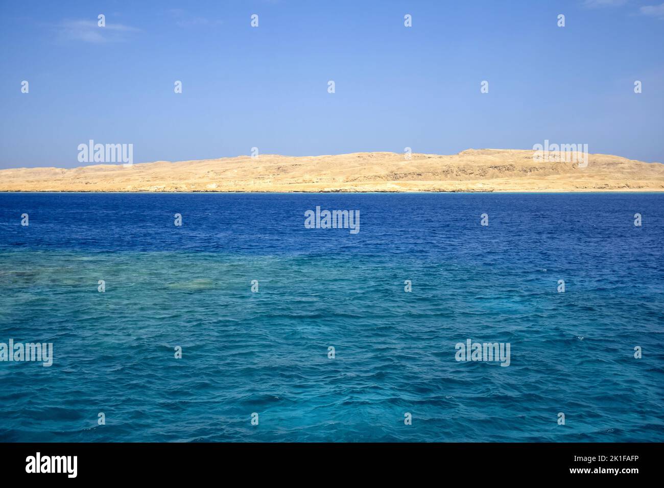 Vacanze, viaggio, vacanza, viaggio in Egitto. Vista dal Mar Rosso all'isola di sabbia deserta contro il cielo azzurro. Spazio di copia. Messa a fuoco selettiva. Foto Stock
