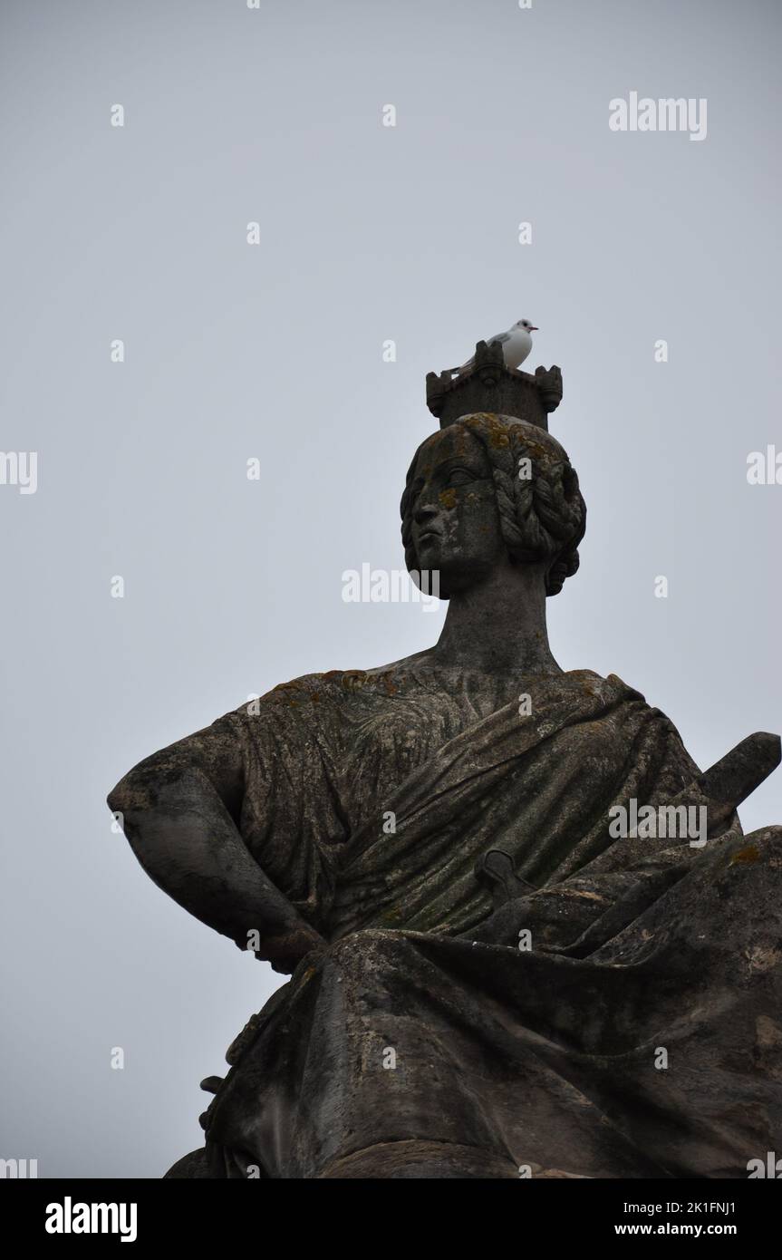 Un uccello sulla testa di una statua di pietra a Parigi, Francia Foto Stock