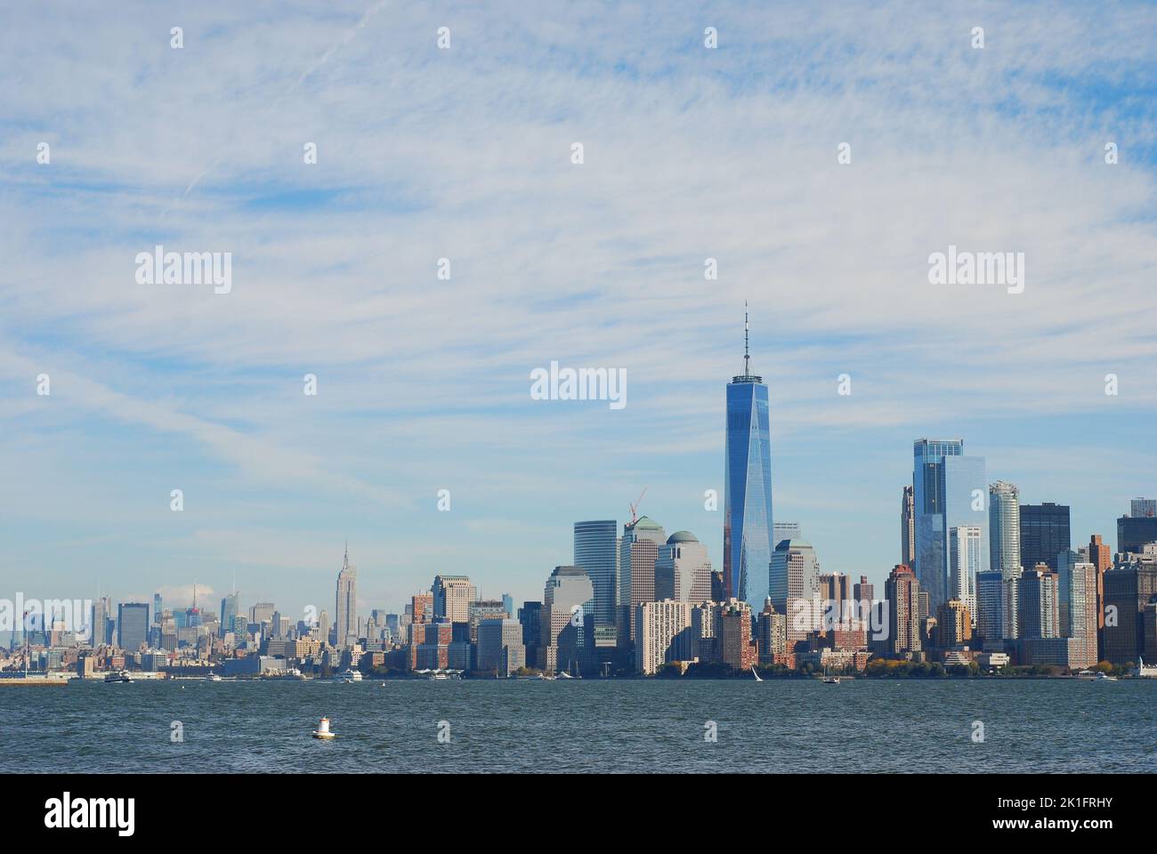Una splendida vista dello skyline di Manhattan con la Freedom Tower su un mare calmo in una giornata di sole Foto Stock