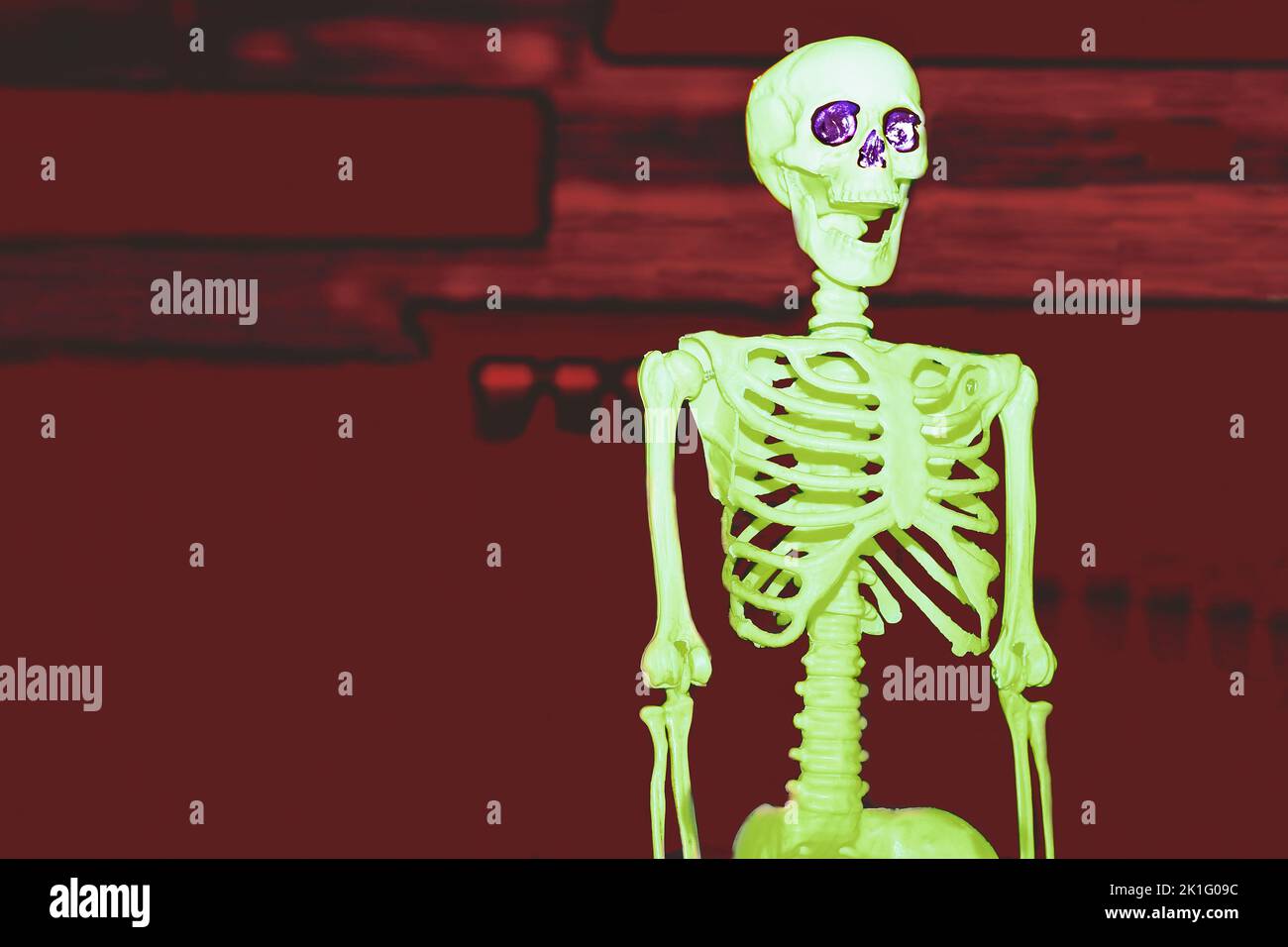 Scheletro velenoso di Halloween verde chiaro su rosso sanguinoso cupo Foto Stock
