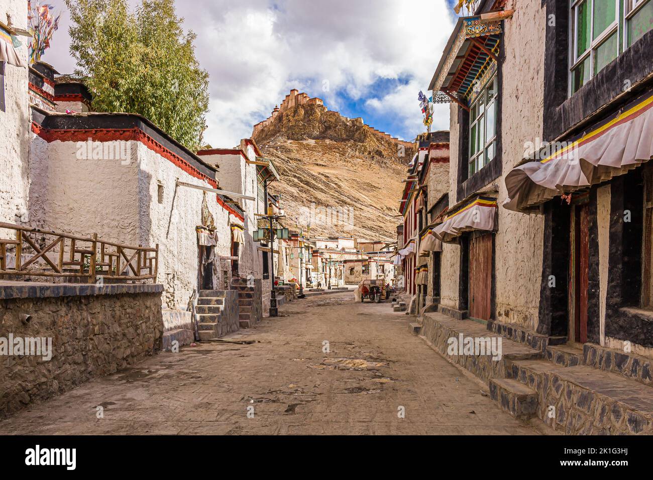Backstreet della città di Gyantse guardando verso la fortezza di dzong nella prefettura di Shigatse, Tibet, Cina Foto Stock