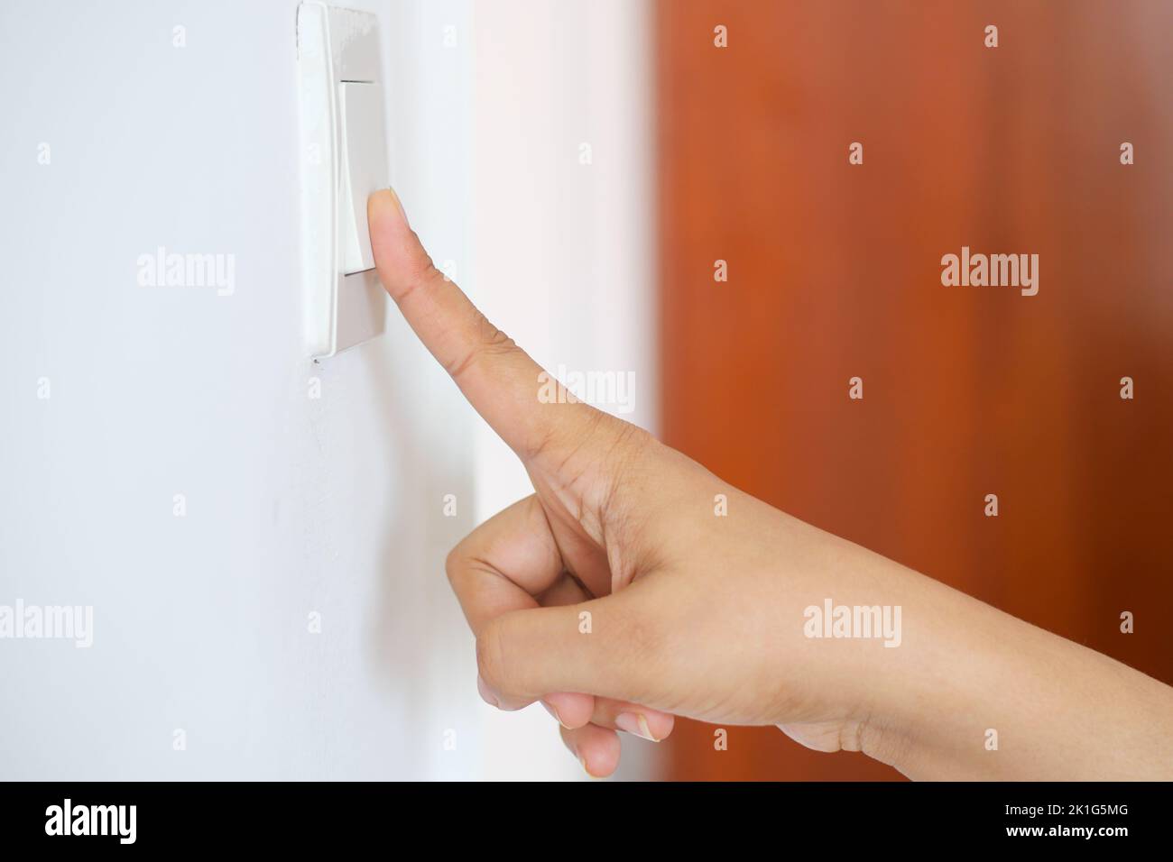 Un dito che accende il contattore delle luci . Foto Stock