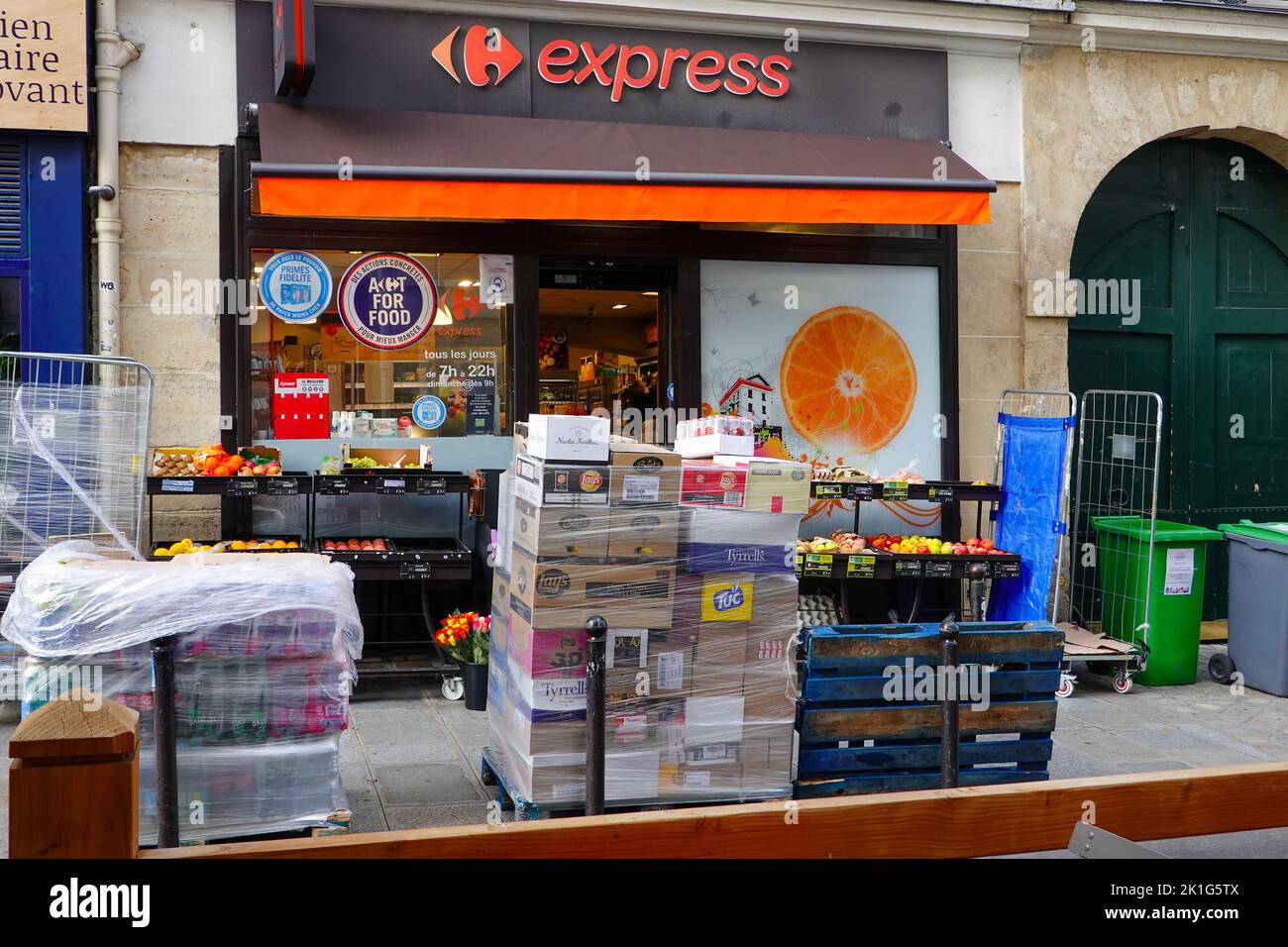 Articoli per la consegna del cibo seduti sul marciapiede, in attesa di essere simballati e collocati sugli scaffali, Carrefour Express, 6th Arrondissement, Parigi, Francia. Foto Stock