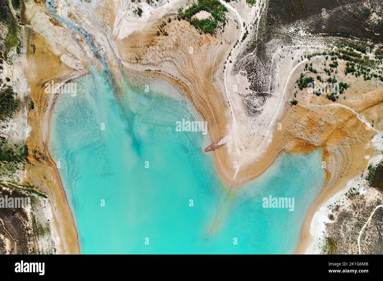 Punto di vista del drone Embalse de la Pedrera grande lago di colore turchese utilizzato come fonte di approvvigionamento idrico, nessuna gente, giorno estivo soleggiato, colori luminosi. Ori Foto Stock