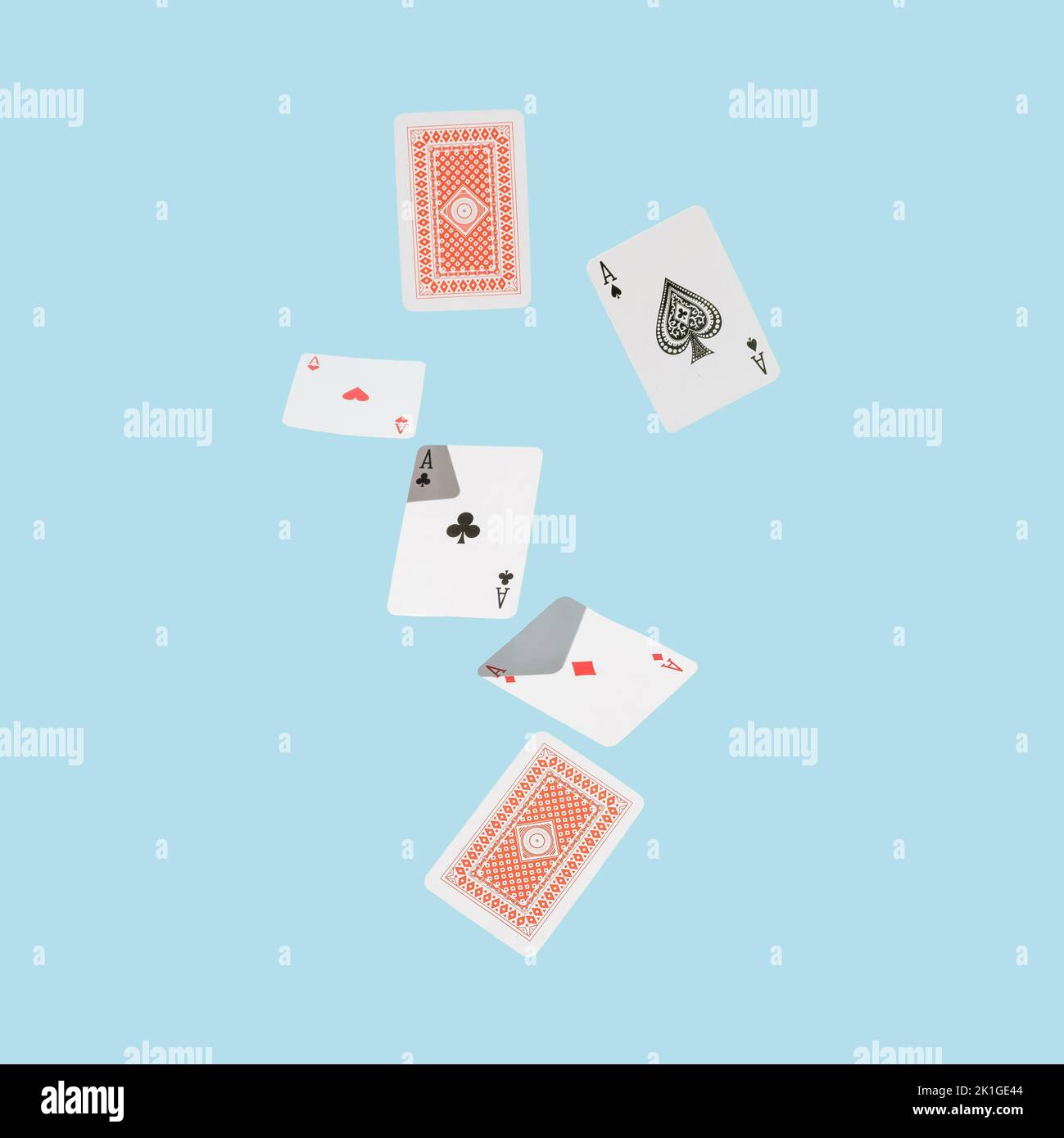 Carte da gioco che cadono contro la superficie blu. Quattro assi. Concetto minimo. Foto Stock