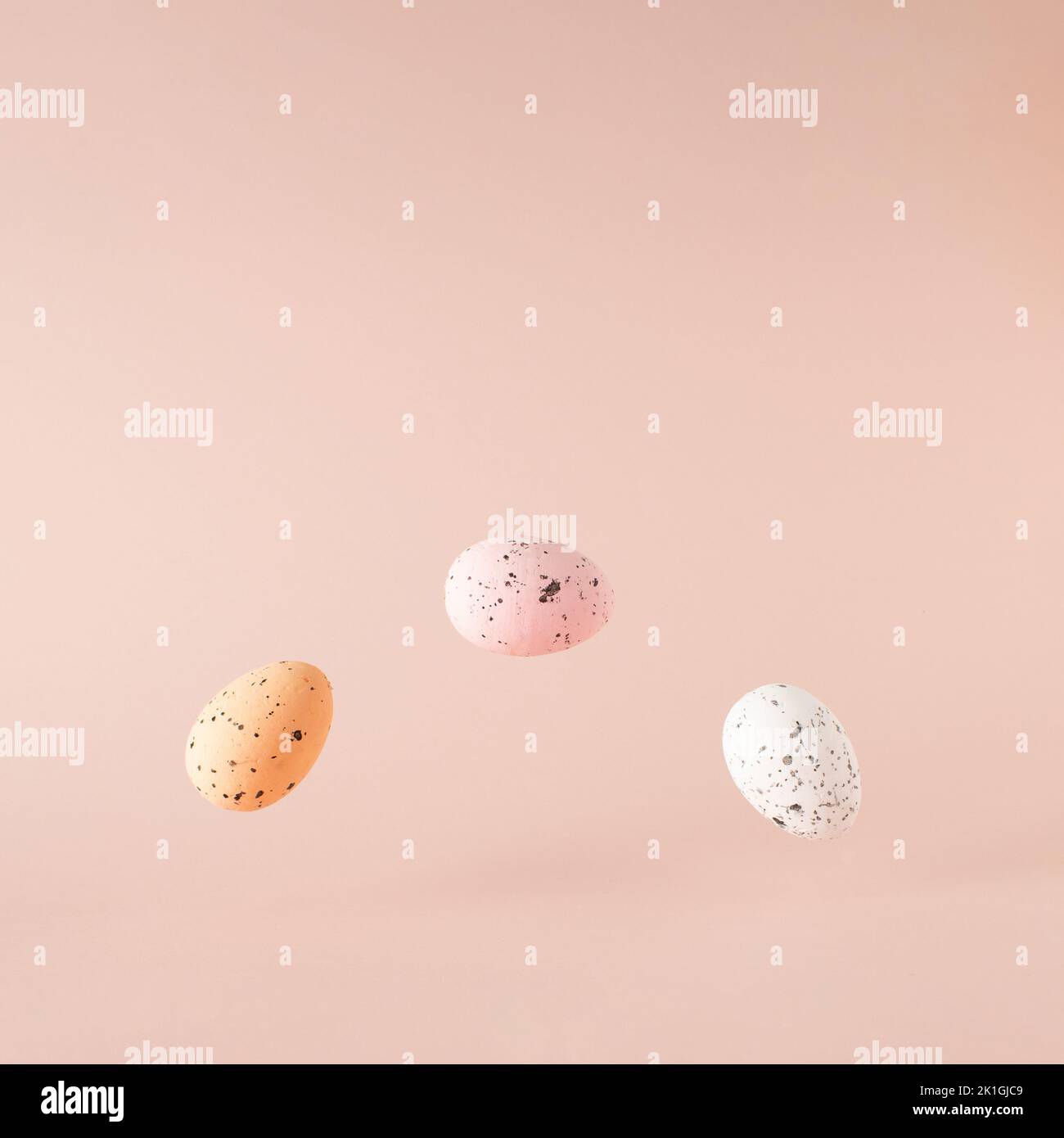 Tre uova di Pasqua in aria su sfondo rosa. Foto Stock