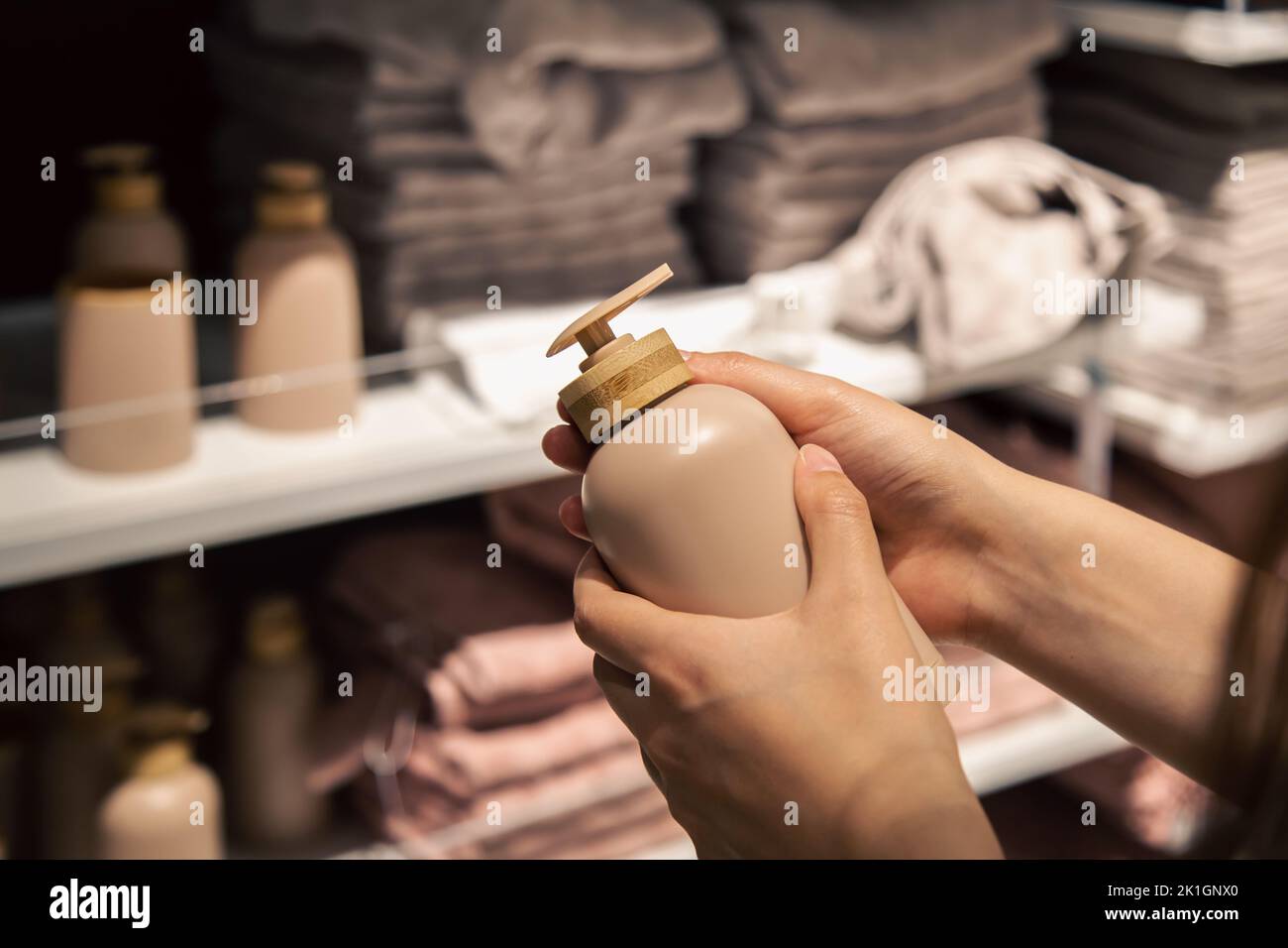 Primo piano, un dispenser per sapone liquido in mani femminili nel negozio. Foto Stock