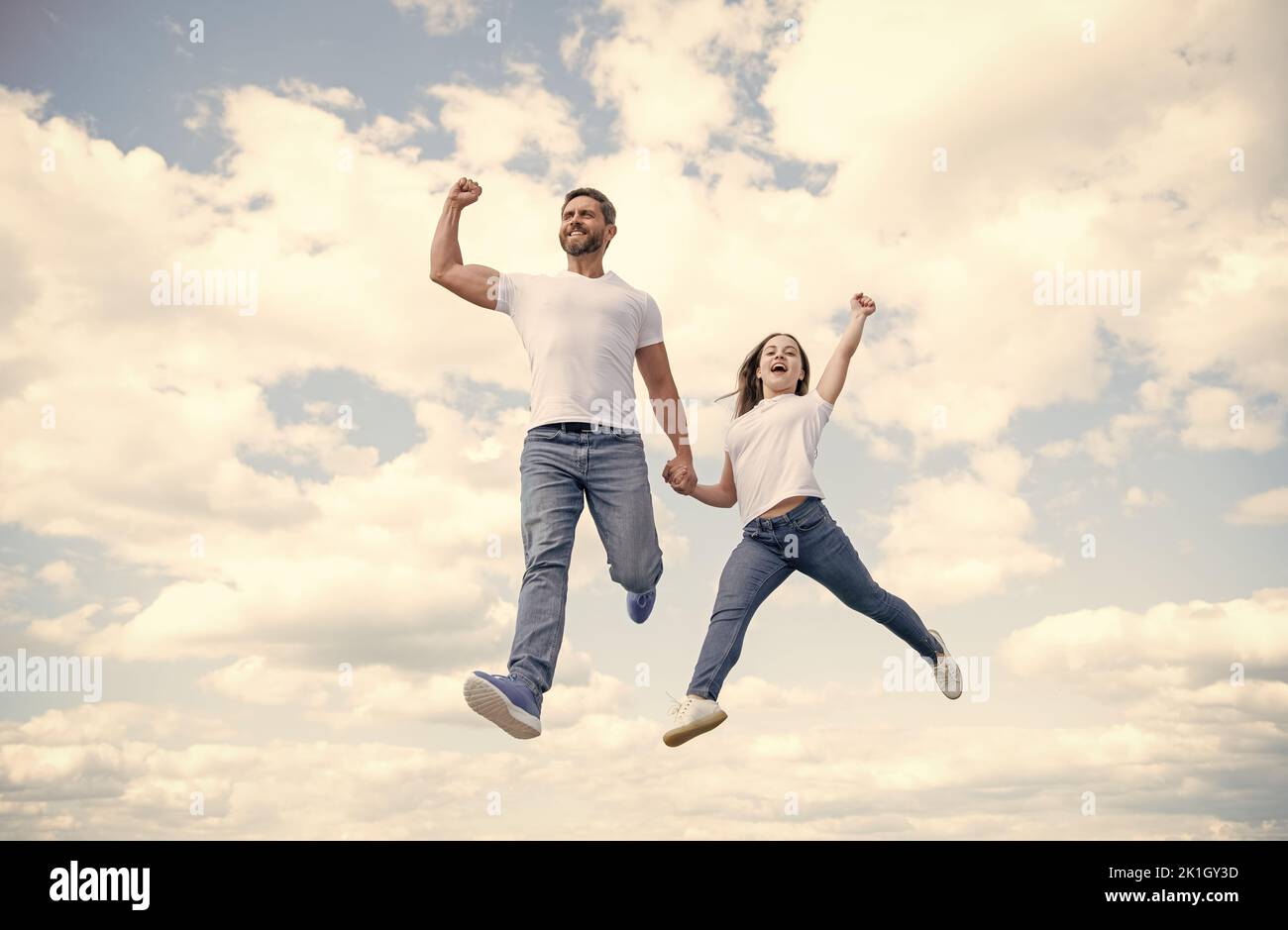 felice padre e figlia saltano nel cielo. felicità Foto Stock