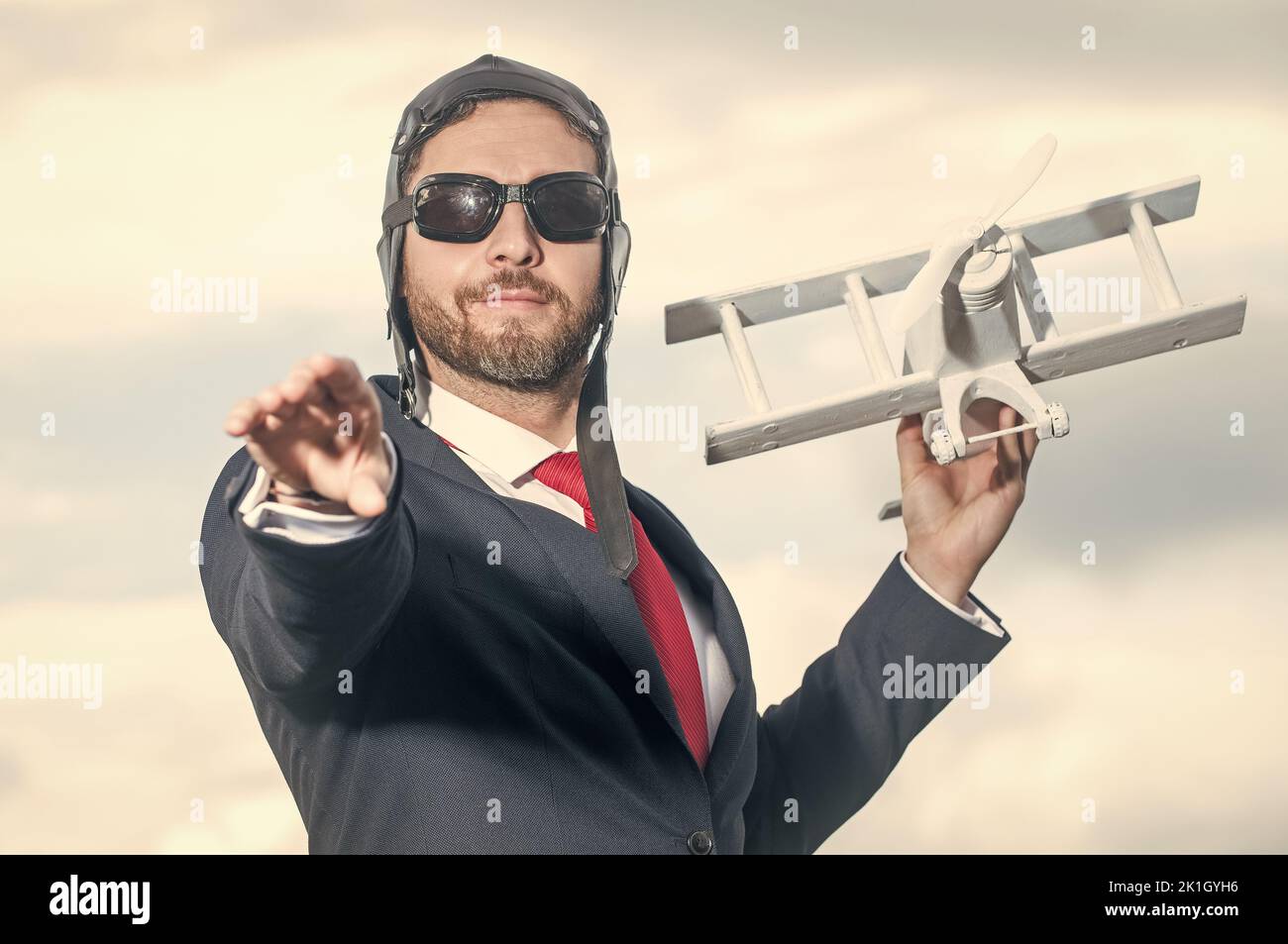 uomo d'affari in abito e cappello pilota lancia giocattolo aereo. opportunità Foto Stock