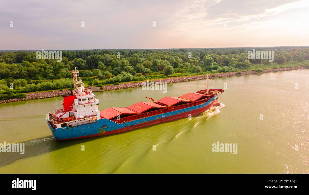 Fotografia aerea di una nave da trasporto merci vista sul Danubio all'alba. La foto è stata scattata da un drone ad un'altitudine più alta con la macchina fotografica abbassata Foto Stock