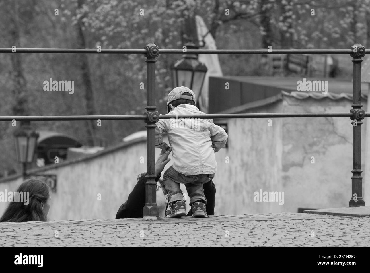 Una scala di grigi di un padre che cattura suo figlio in un parco a Praga, Repubblica Ceca Foto Stock