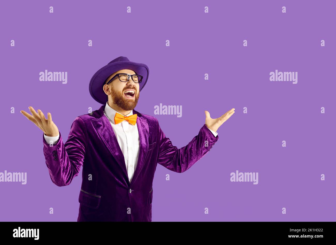 Felice eccentrico uomo isolato su sfondo viola ridendo forte dopo aver sentito scherzo divertente Foto Stock