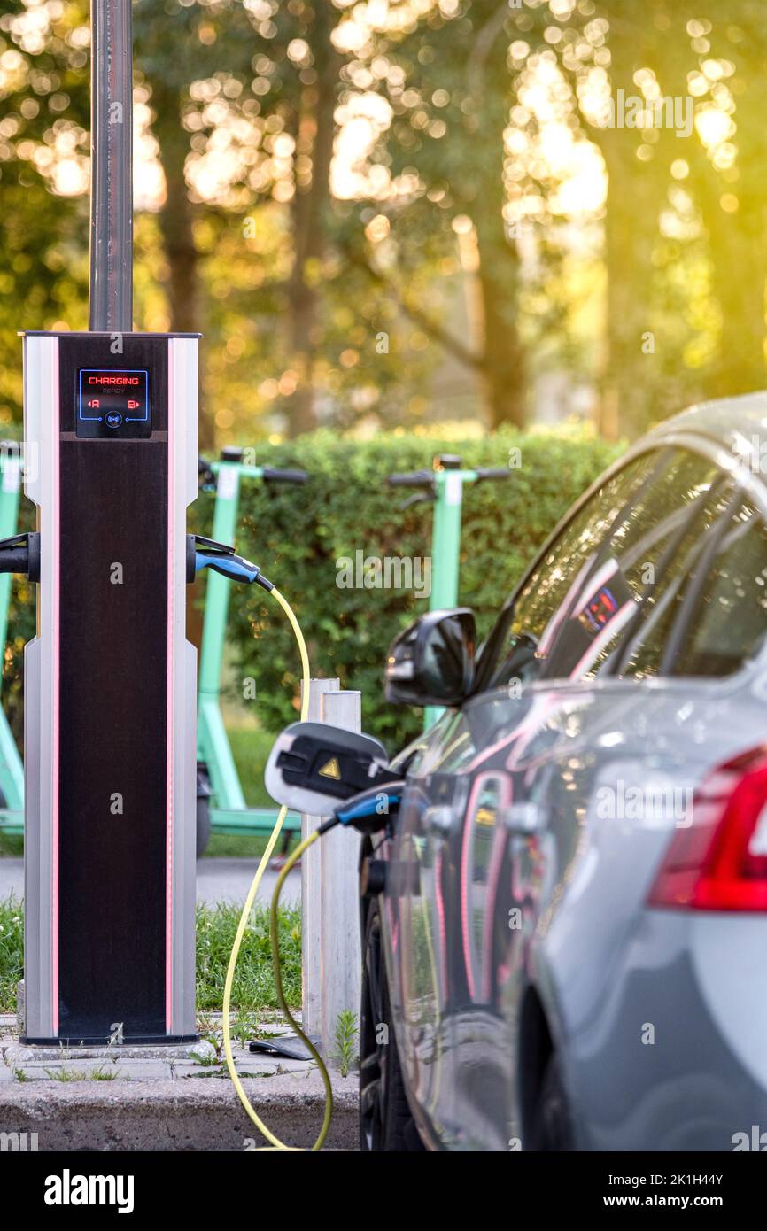 Ricarica di veicoli elettrici moderni in una stazione stradale. Il processo di ricarica di un'auto elettrica. Foto Stock