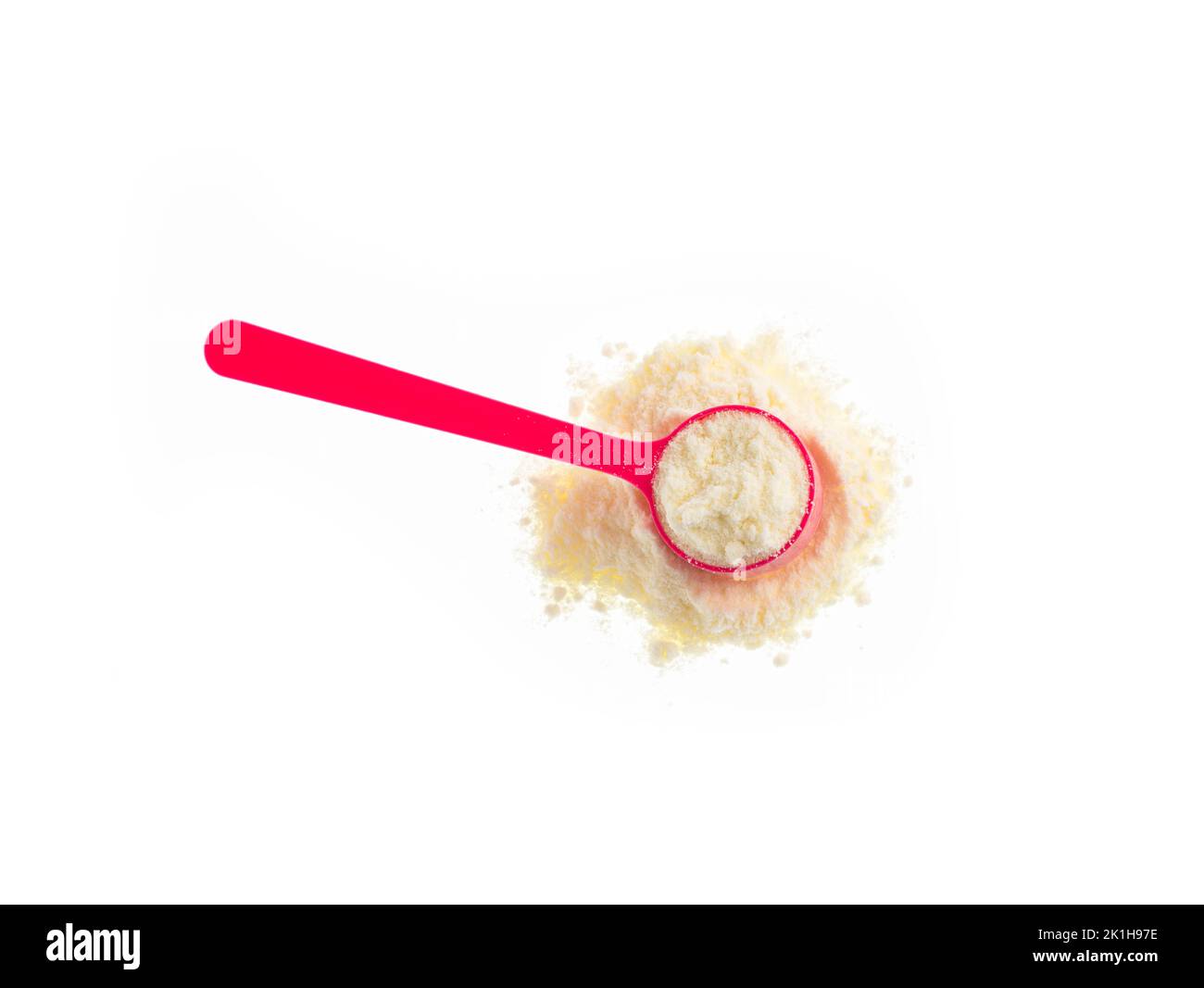 Latte in polvere o disidratato nel cucchiaio rosa Foto Stock