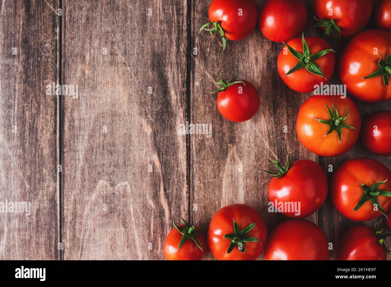 Pomodori su vecchio tavolo di legno, verdure fresche di pomodoro rosso piatto giaceva con spazio copia Foto Stock