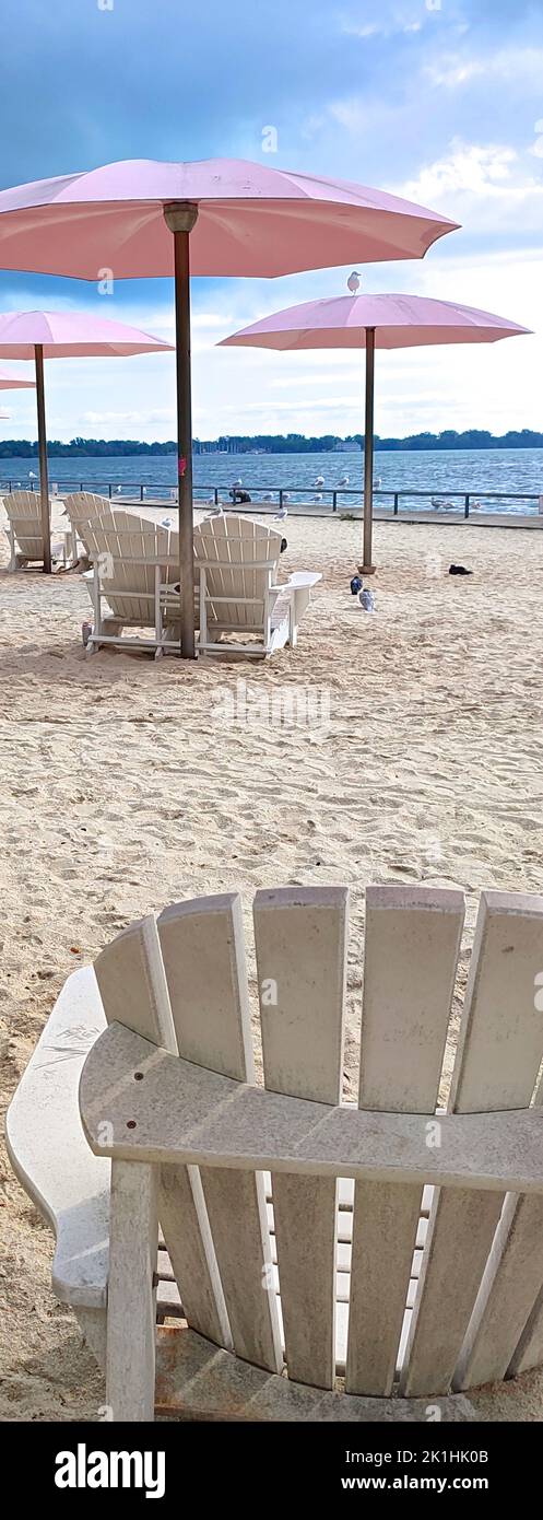 Banner Web di un parco pubblico sulla spiaggia in città con ombrelloni rosa in una calda giornata estiva Foto Stock