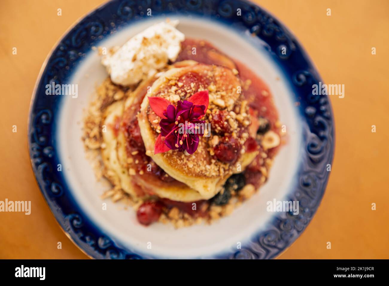 Appetitose frittelle decorate con frutti di bosco e fiori. Foto Stock