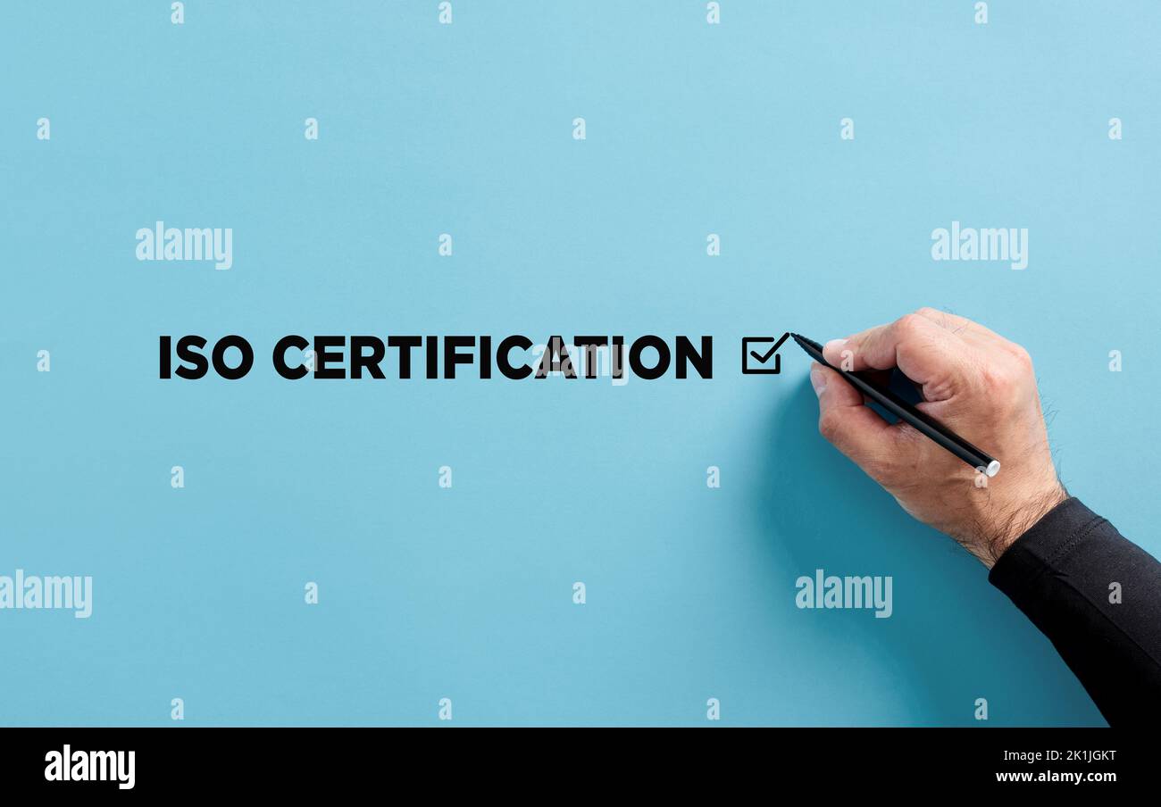 La mano maschile mette un segno di spunta sul messaggio certificazione ISO. Concetto di approvazione della certificazione ISO. Foto Stock