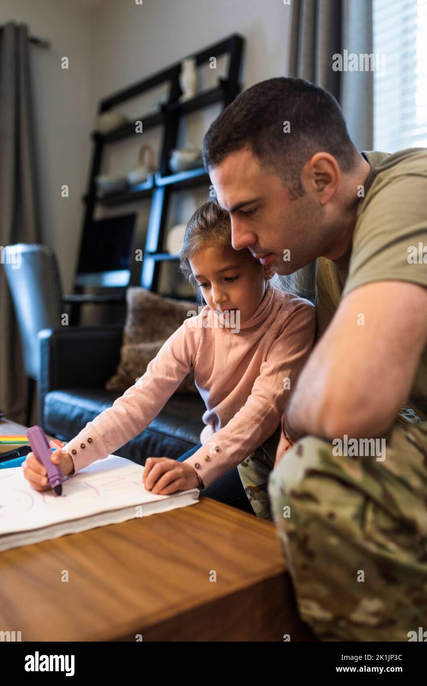 Soldato padre e figlia colorazione in soggiorno Foto Stock