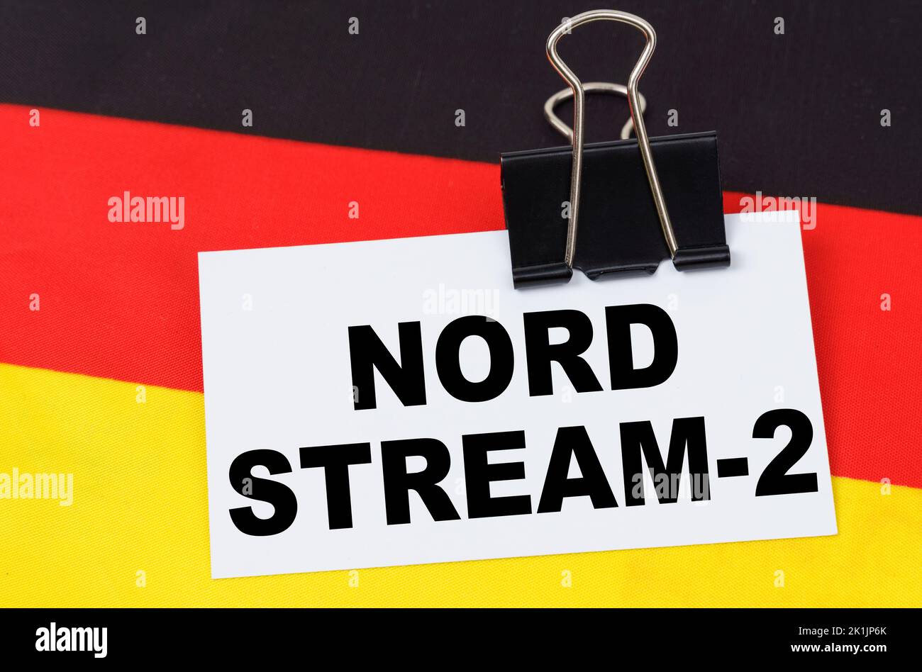 Concetto di economia nazionale. Sulla bandiera della Germania si trova un quaderno con l'iscrizione - Nord Stream 2 Foto Stock