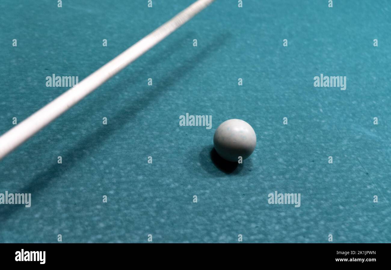 Cue ball su un vecchio tavolo da biliardo logoro. Un gioco di piscina con attrezzature usate. Foto Stock