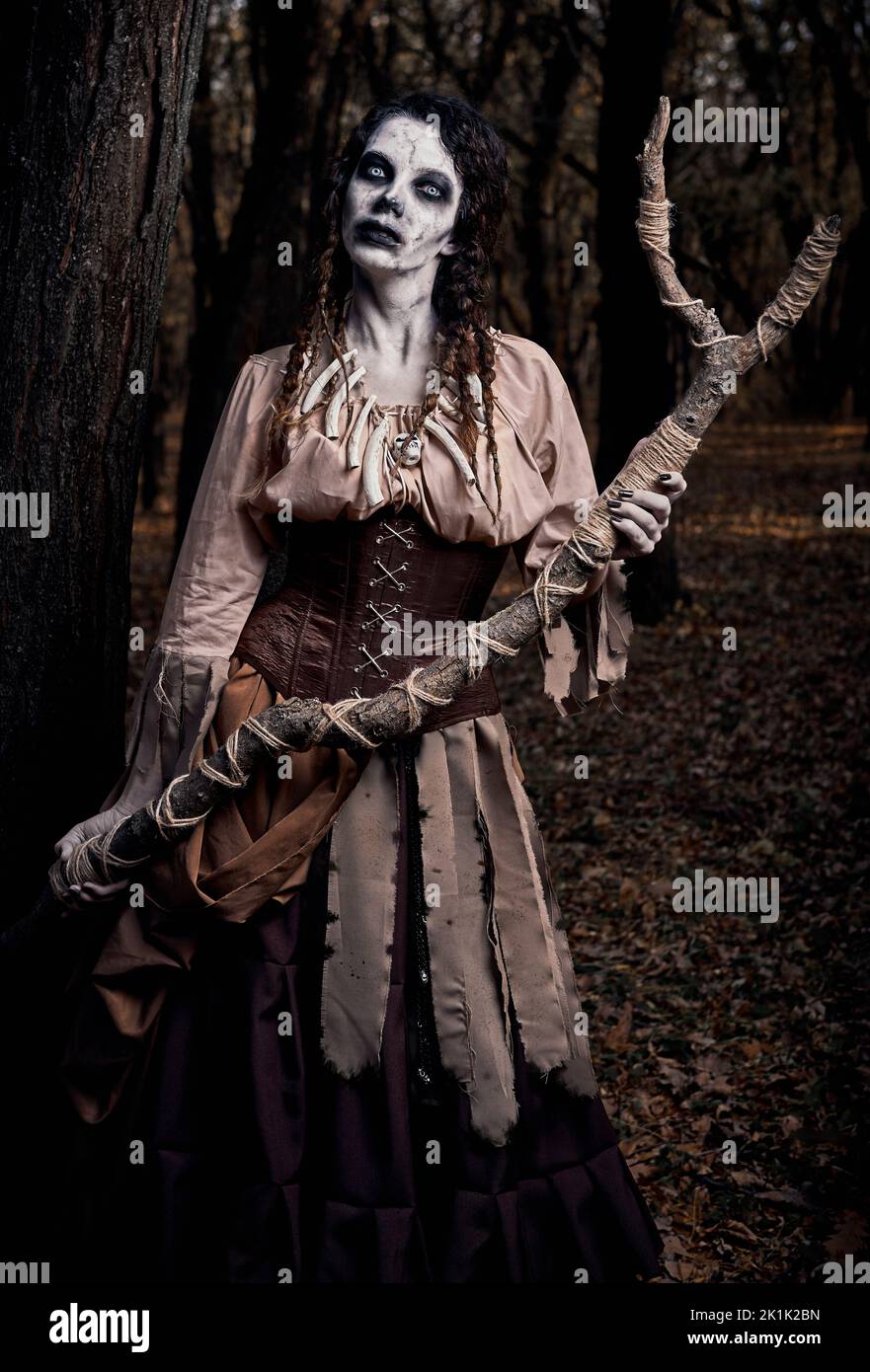 Tema di Halloween (Samhain): Brutto terribile voodoo strega con il personale. Ritratto della malvagia hag nella foresta scura. Donna zombie (non morta) Foto Stock