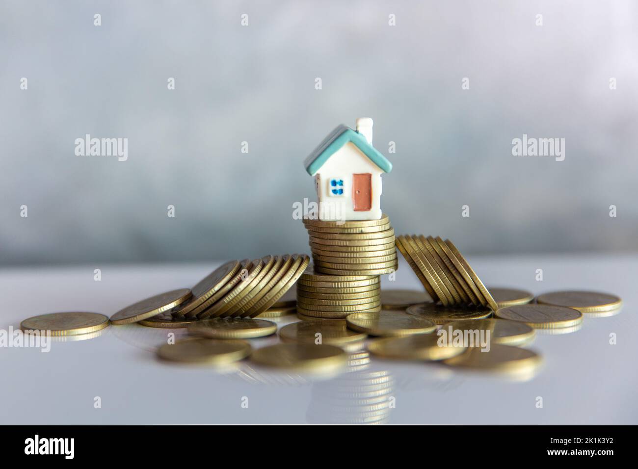 Mini casa su pila di monete, denaro e casa, ipoteca, risparmio di denaro per acquistare casa e prestito per gli investimenti aziendali per il concetto immobiliare. Invesmen Foto Stock