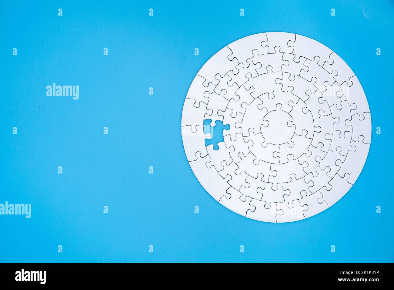 Pezzi di puzzle jigsaw bianco incompiuto su sfondo blu, l'ultimo pezzo di puzzle jigsaw, Copia spazio. Foto Stock