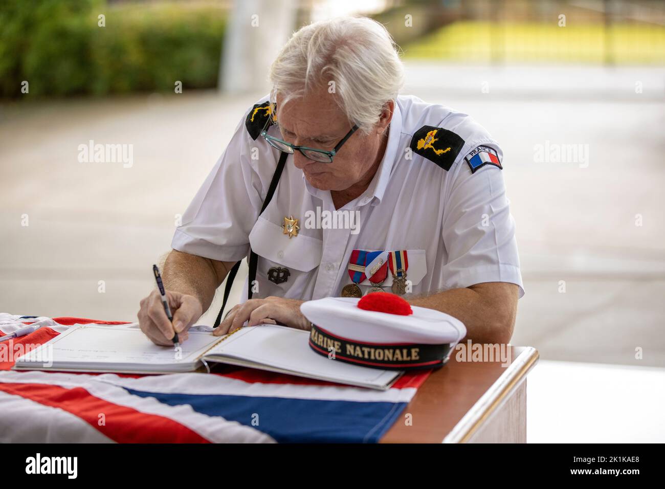 Pattaya, Thailandia. 19th Set, 2022. Un veterano della Marina Nationale francese firma il libro di condoglianze durante uno speciale servizio commemorativo che segna la morte di sua Maestà la Regina Elisabetta II al Mahatai Convention Center Fondazione Padre Rays il 19 settembre 2022 a PATTAYA, THAILANDIA (Foto di Peter van der KloosterAlamy Live News) Credit: peter Van der Klooster/Alamy Live News Foto Stock