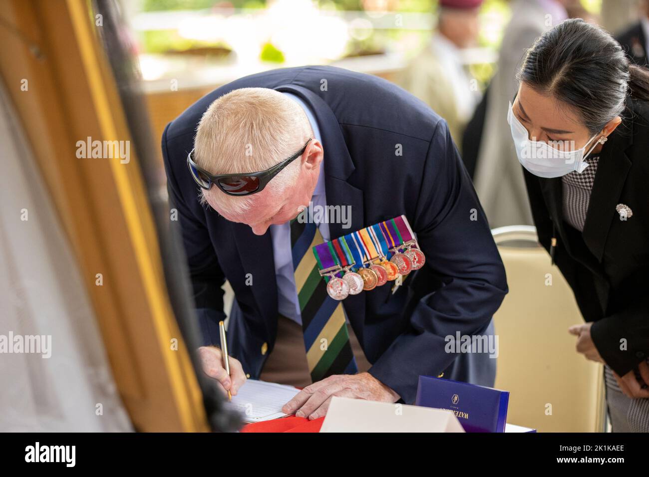 Pattaya, Thailandia. 19th Set, 2022. Un veterano decorato firma il libro di condoglianze durante un servizio speciale di commemorazione che segna la morte di sua ultima Maestà la Regina Elisabetta II al Mahatai Convention Center Fondazione Padre Rays il 19 settembre 2022 a PATTAYA, THAILANDIA (Foto di Peter van der KloosterAlamy Live News) Credit: peter Van der Klooster/Alamy Live News Foto Stock