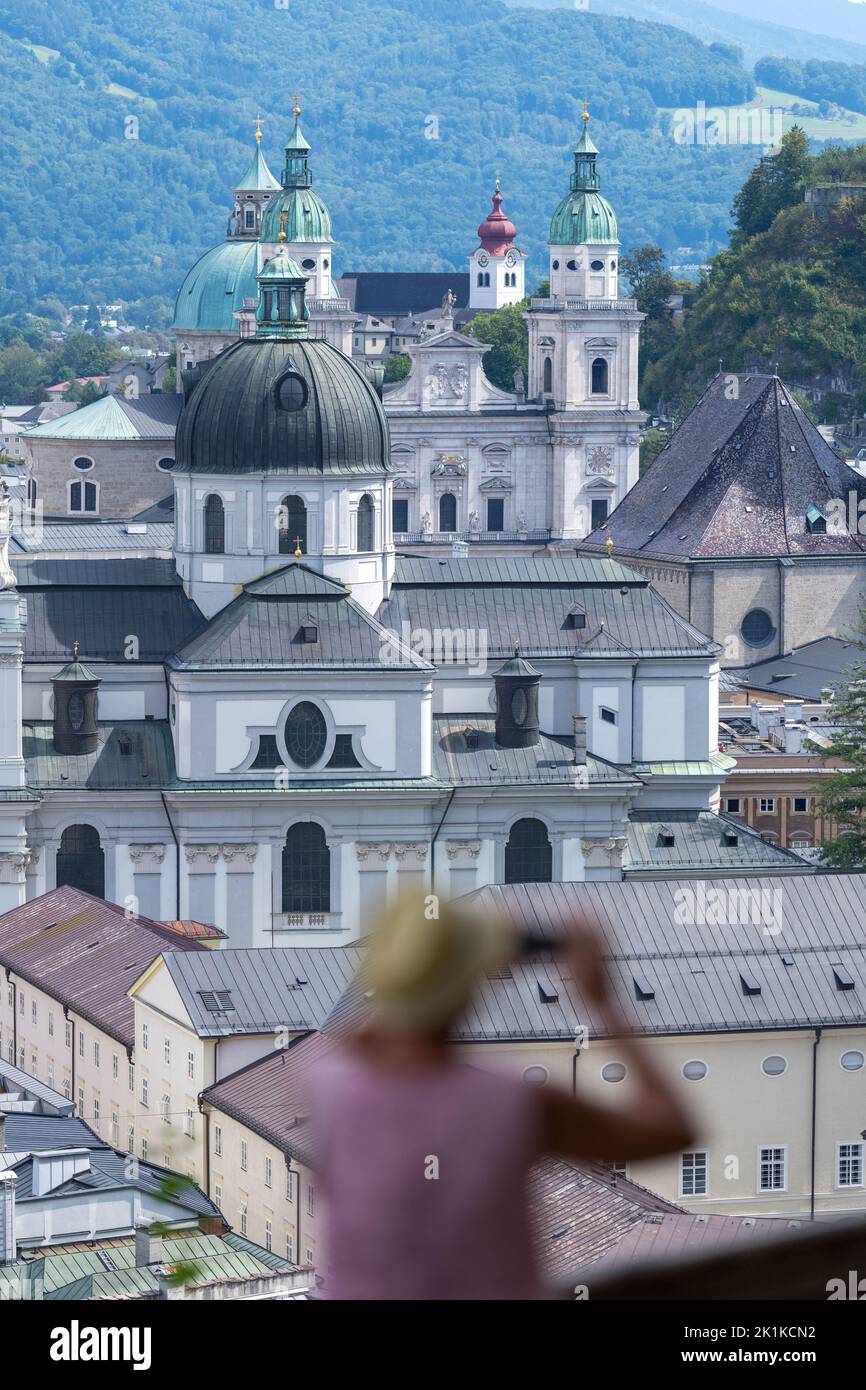 Vista posteriore di una donna che fotografa la cattedrale e il paesaggio urbano, Salisburgo, Austria Foto Stock