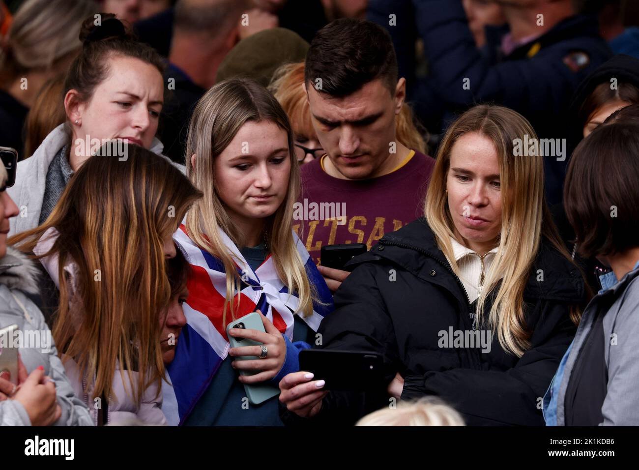 La gente guarda i funerali di stato e la sepoltura della regina Elisabetta britannica al telefono, a Londra, Gran Bretagna, 19 settembre 2022. REUTERS/Tom Nicholson Foto Stock