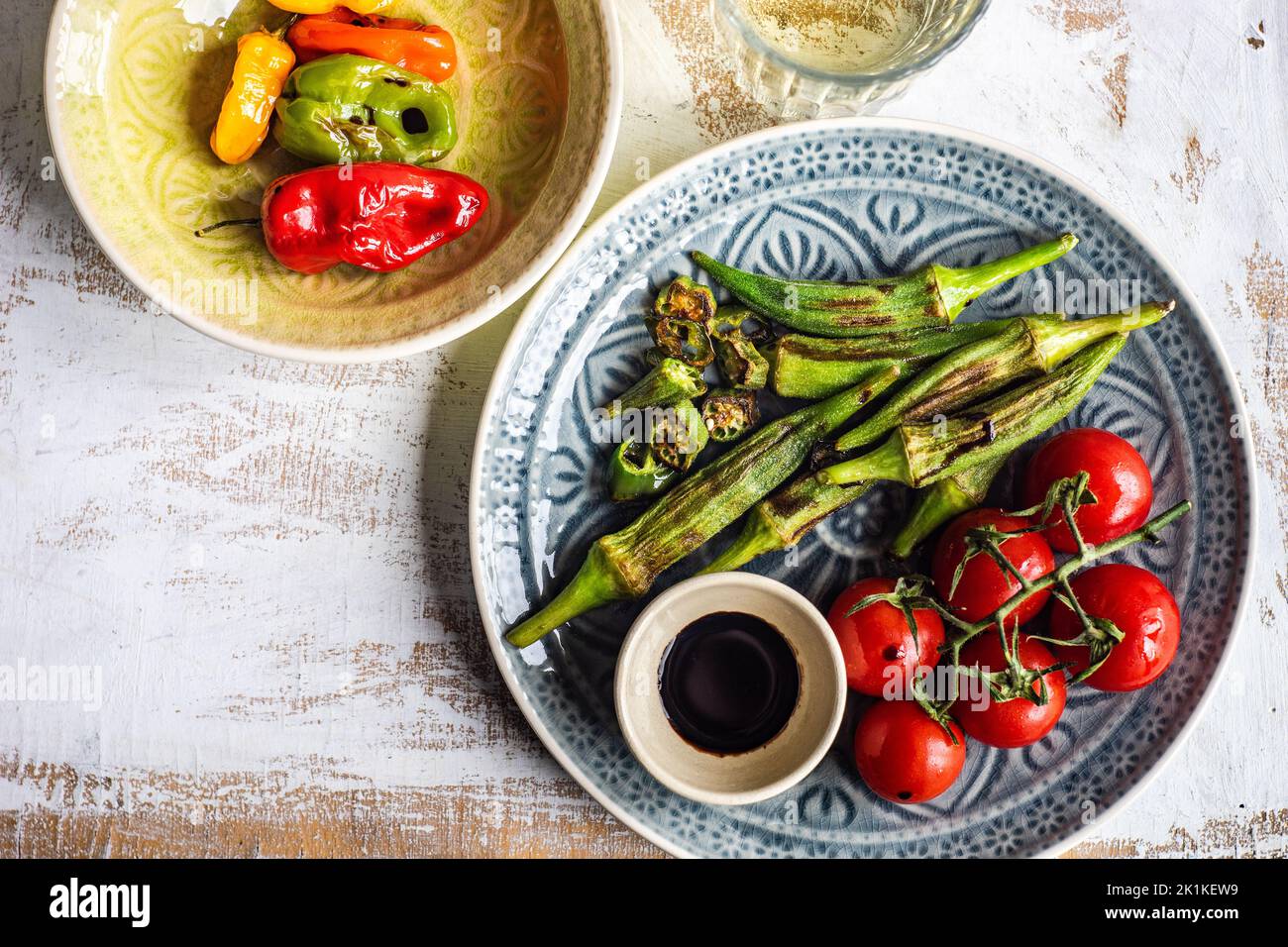 Vista dall'alto di okra arrosto, pomodori e peperoni con condimento balsamico di soia Foto Stock