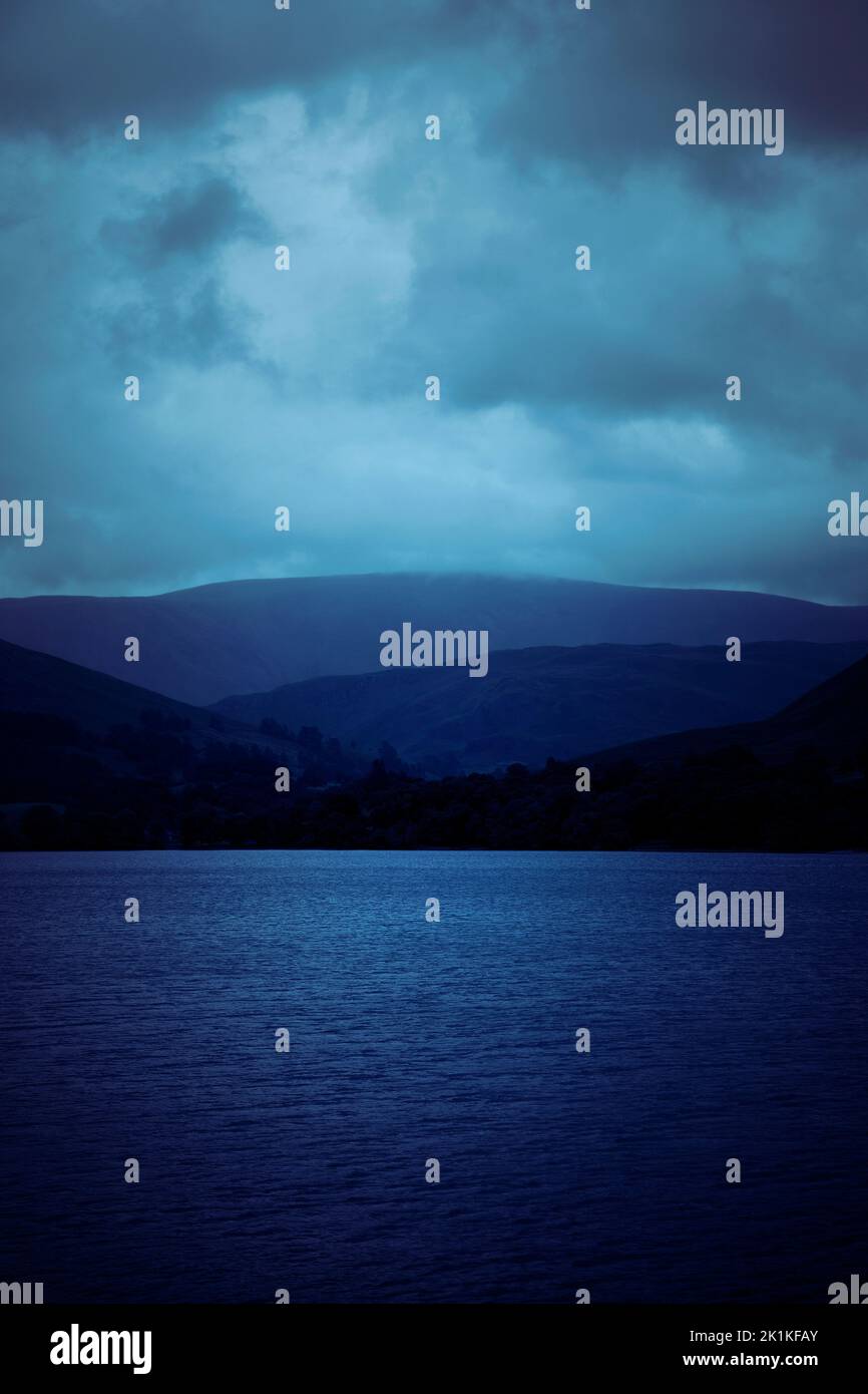 Montagne che si affacciano sul lago in Moody Overcast tempo Foto Stock