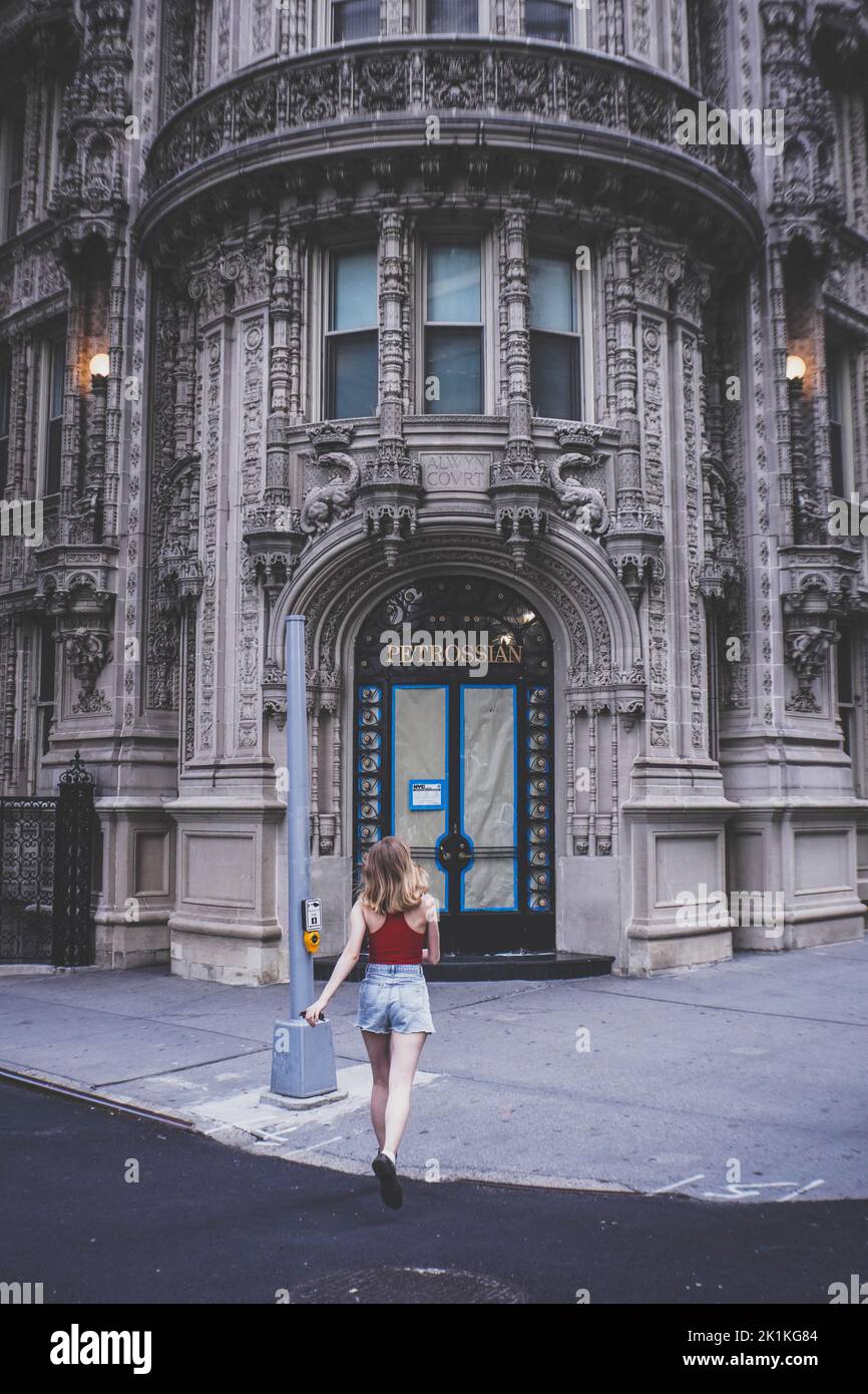 Una vista verticale della ragazza che corre verso l'edificio Petrossian a New York Foto Stock