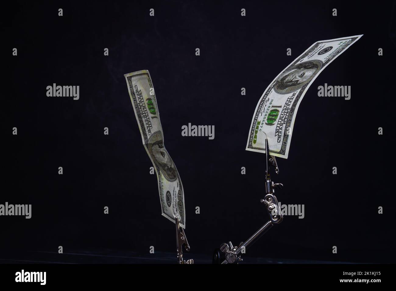Chiudere i supporti metallici con cento dollari. Isolato su sfondo nero. Foto Stock