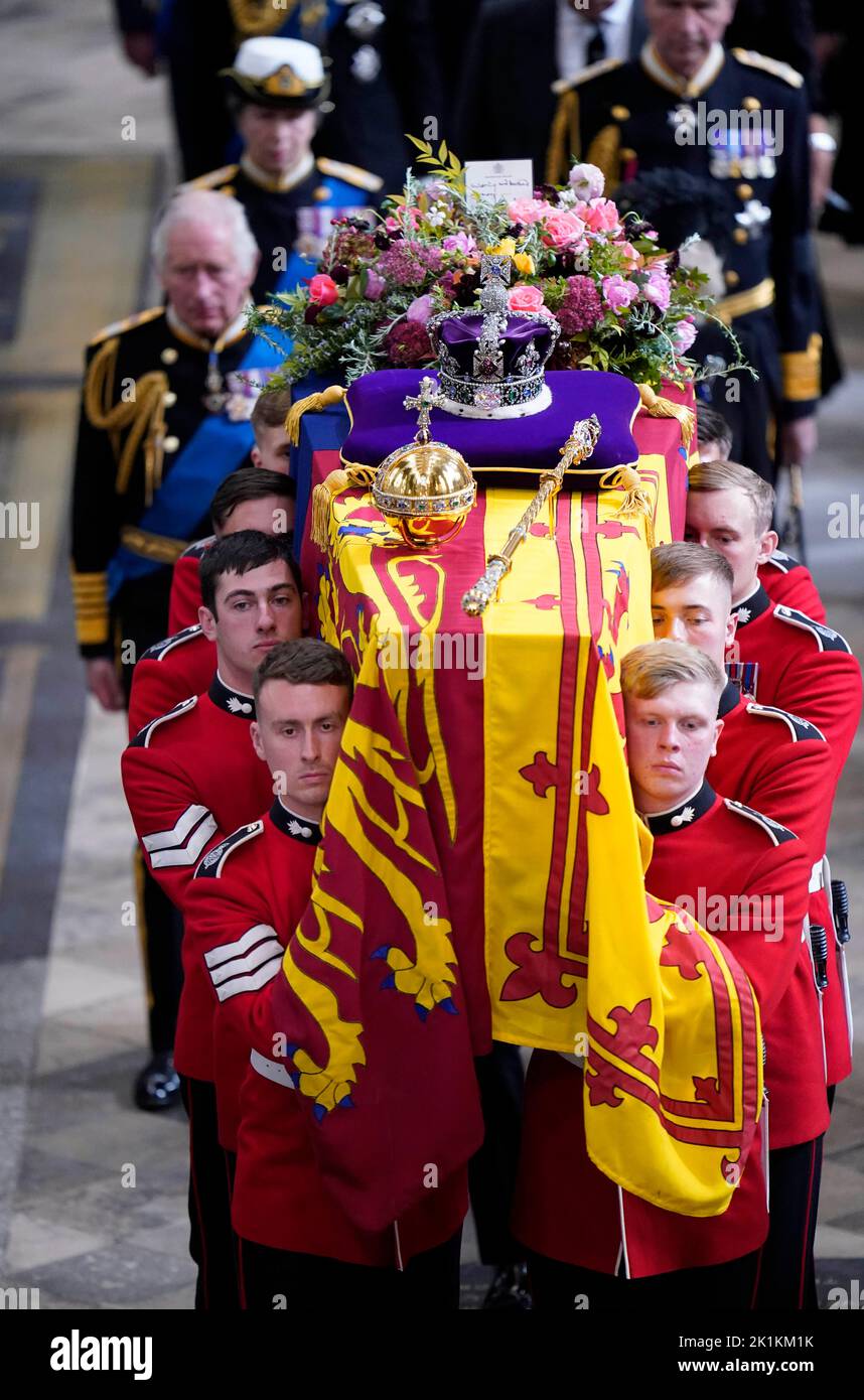 Re Carlo III e i membri della famiglia reale seguono dietro la bara della regina Elisabetta II, drappeggiato nello Standard reale con la corona di Stato imperiale e l'orbo e scettro del Sovrano, come viene eseguito dall'Abbazia di Westminster dopo il suo funerale di Stato. Data immagine: Lunedì 19 settembre 2022. Foto Stock