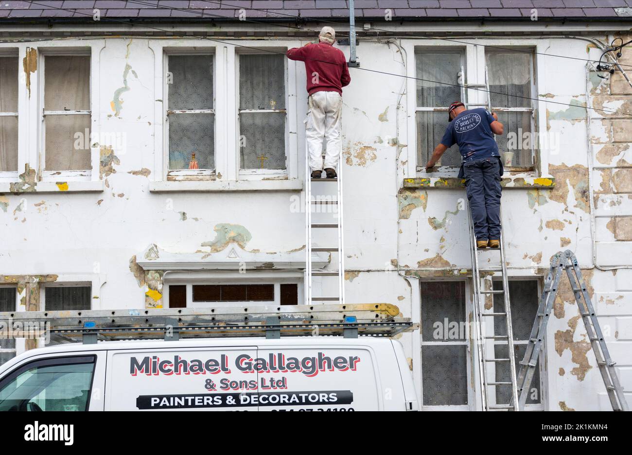 Pittori locali e decoratori al lavoro su una casa in Ardara, Contea di Donegal, Irlanda Foto Stock