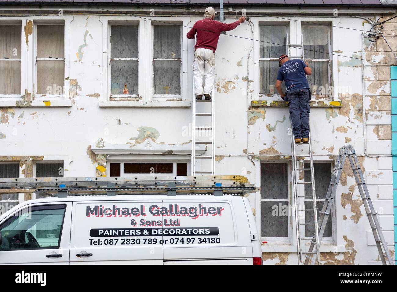 Pittori locali e decoratori al lavoro su una casa in Ardara, Contea di Donegal, Irlanda Foto Stock