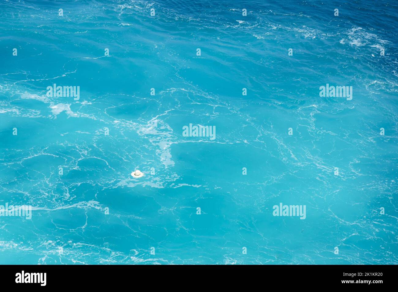 Un cappello di paglia che galleggia in un mare blu, mar egeo, grecia Foto Stock