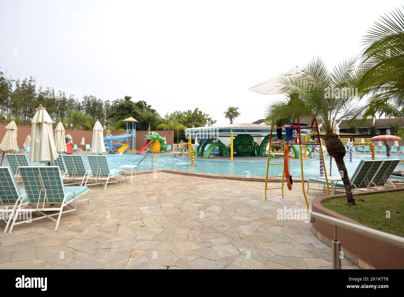 Piscine di un resort di lusso con giocattoli per bambini e lettini sullo sfondo di un cielo nuvoloso e con vista panoramica ad ampio angolo Foto Stock