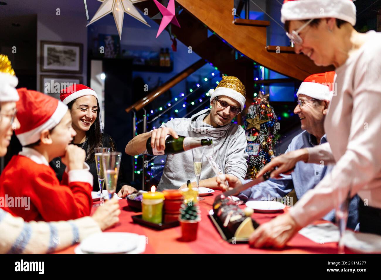 Famiglia felice multi generazionale in cappelli di Santa celebrare il natale a casa Foto Stock