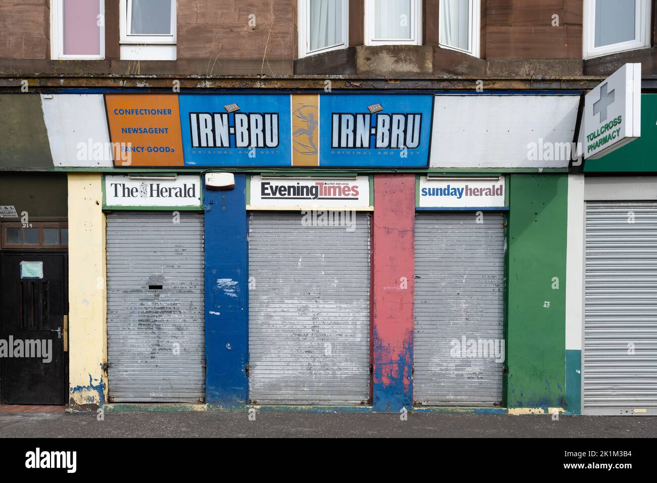 Edicola chiusa e chiusa con cartello Irn Bru, Tollcross Road, Parkhead, Glasgow, Scozia, REGNO UNITO Foto Stock